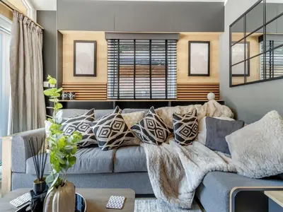 a living room with a gray couch with pillows at Aqueduct Hideaway in Llangollen