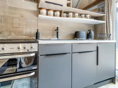 a kitchen with white cabinets and an oven at Aqueduct Hideaway in Llangollen