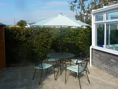 a table and chairs with an umbrella on a patio at Sisial y Llyn in Bala