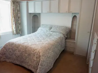 a bedroom with a bed with a white comforter at Sisial y Llyn in Bala