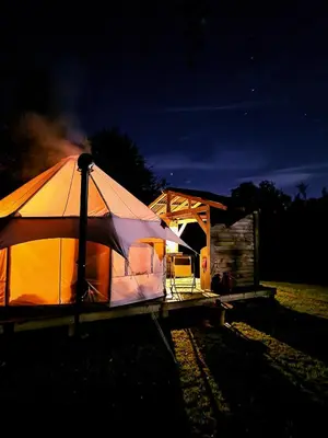 a lit up tent next to a building at night at Taylor the Burt in Penuwch