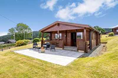 a small wooden cabin with chairs in a field at 1 Bed in Llandinam oc-t33065 in Llandinam