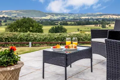 a table with a plate of food and two glasses of orange juice at 1 Bed in Llandinam oc-t33065 in Llandinam