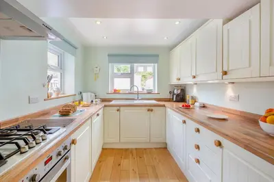 a kitchen with white cabinets and a stove top oven at 4 Bed in Barmouth oc-n32921 in Barmouth