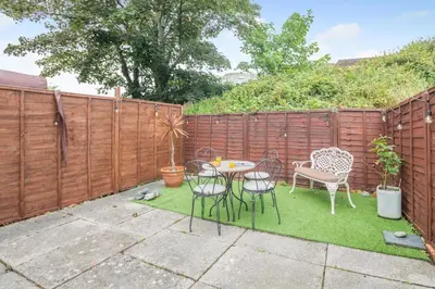 a patio with a table and chairs and a fence at 4 Bed in Barmouth oc-n32921 in Barmouth