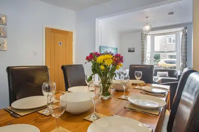 a dining room table with a vase of flowers on it at 4 Bed in Barmouth oc-n32921 in Barmouth