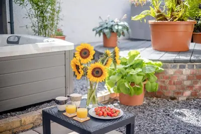 a table with a vase of sunflowers and a plate of fruit at 1 Bed in Capel Bangor oc-y33024 in Capel Bangor