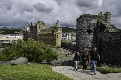 a group of people walking past a castle at 1 Bed in Capel Bangor oc-y33024 in Capel Bangor