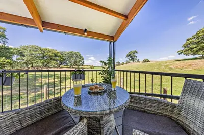 a patio with a table and chairs on a balcony at 1 Bed in Llandeilo oc-w33068 in Llanddeusant