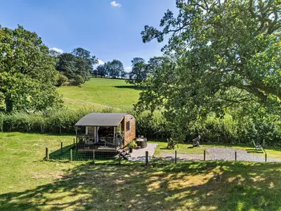 a small cabin in a field with a tree at 1 Bed in Llandeilo oc-w33068 in Llanddeusant