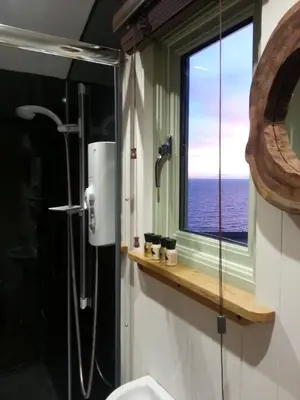a bathroom with a shower and a window at The Farm Hut in Barmouth