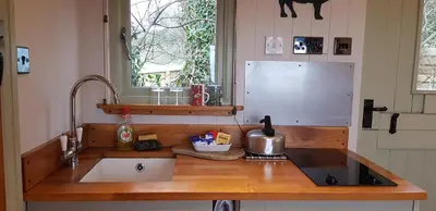 a kitchen counter with a sink and a refrigerator at The Farm Hut in Barmouth