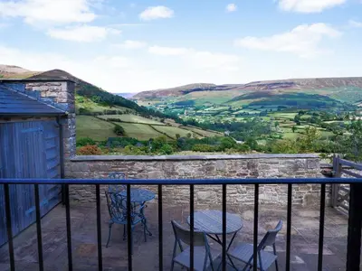 a view from the balcony of a house with a table and chairs at Mountain View Farm Cottage in Crickhowell