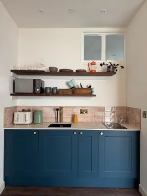 a kitchen with blue cabinets and a sink at The Library Cottage at The Old Library in Aberystwyth