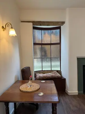 a room with a wooden table and a window at The Library Cottage at The Old Library in Aberystwyth