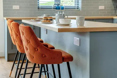 a kitchen with a counter with orange bar stools at 4 Bed in Brecon oc-m32973 in Brecon