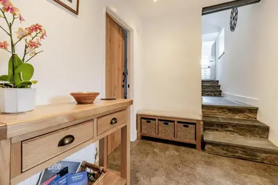 a hallway with a wooden dresser and a staircase at 3 Bed in Tywyn oc-h32633 in Tywyn