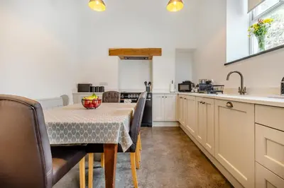 a kitchen with a table and some chairs and a sink at 3 Bed in Tywyn oc-h32633 in Tywyn