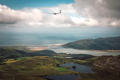 a plane flying in the sky over a lake at 3 Bed in Tywyn oc-h32633 in Tywyn