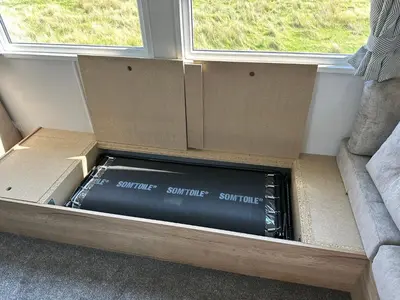 a box that is sitting next to a couch at Luxury static caravan on SunnySands with mountain views in Barmouth
