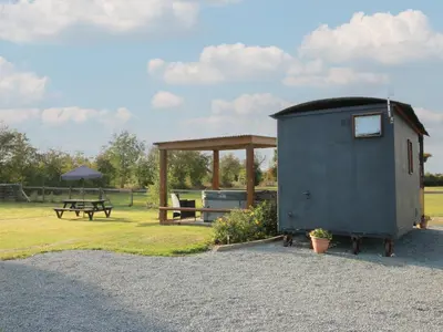 a smallshed with a picnic table and a bench at Sharon's Shepherd Hut in Oswestry