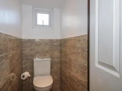 a bathroom with a toilet and a window at Sharon's Shepherd Hut in Oswestry
