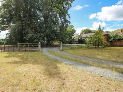 a dirt road in a field next to a fence at The Coach House in Church Stretton
