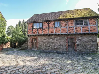 an old brick house on a cobblestone street at The Coach House in Church Stretton