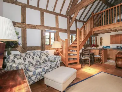 a living room with a couch and a staircase at Courtyard Cottage in Church Stretton