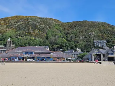a town on the beach with a mountain in the background at Charming Welsh Cottage in Dolgellau - Snowdonia in Dolgellau