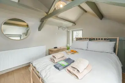 a bedroom with a large bed with towels on it at Charming Welsh Cottage in Dolgellau - Snowdonia in Dolgellau