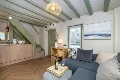 a living room with a blue couch and a table at Charming Welsh Cottage in Dolgellau - Snowdonia in Dolgellau