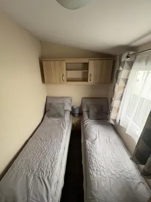two beds in a small room with a window at T&J Seaview at Pengarreg in Llanrhystyd
