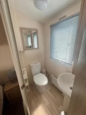 a bathroom with a toilet and a sink at T&J Seaview at Pengarreg in Llanrhystyd