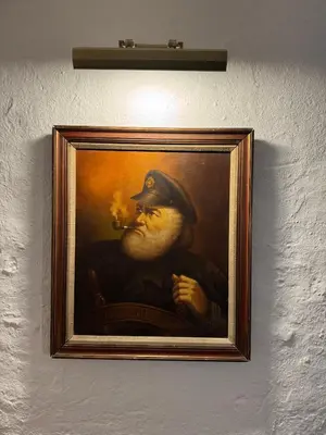 a painting of a man smoking a pipe at Fishermans Cottage at The Old Library in Aberystwyth