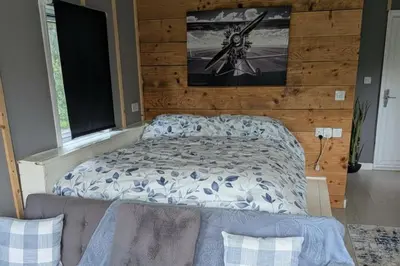 a bedroom with a bed and a couch in it at Tranquil Cabin Retreat- Sleeps 2 Parking in Welshpool