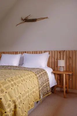 a bedroom with a bed and a table with a lamp at Amberwood Lodge in Hay-on-Wye