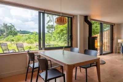 a dining room with a table and chairs and a large window at Brackenfell Lodge in Hay-on-Wye