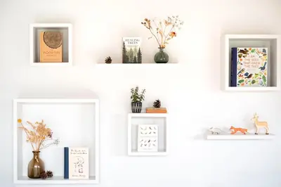 four white shelves with plants and vases on them at Brackenfell Lodge in Hay-on-Wye