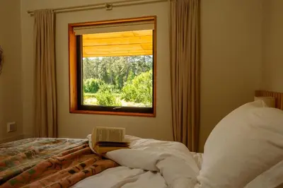 a bedroom with a window with a book on a bed at Cedar Lodge in Hay-on-Wye