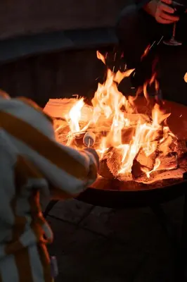 a person is reaching into a fire pit at Cedar Lodge in Hay-on-Wye