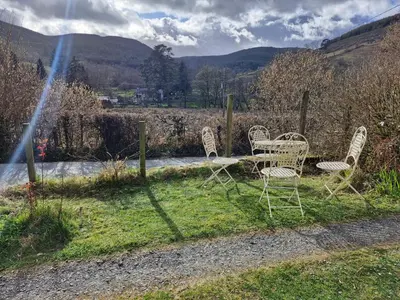 a group of chairs sitting in the grass at Rustic Welsh cottage in Llanwrtyd Wells
