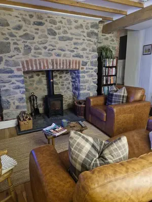 a living room with couches and a stone fireplace at Rustic Welsh cottage in Llanwrtyd Wells