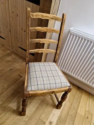 a wooden chair sitting in a room next to a radiator at Rustic Welsh cottage in Llanwrtyd Wells
