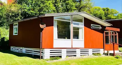 a red and orange house with a window at Chalet 8 Erw Porthor Happy valley in Tywyn