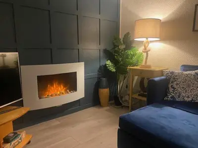 a living room with a fireplace in the wall at Chalet 8 Erw Porthor Happy valley in Tywyn