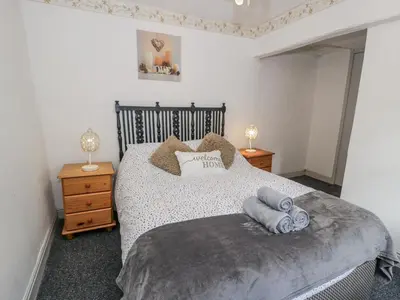 a bedroom with a bed with two night stands and two lamps at Old Post Office in Maentwrog