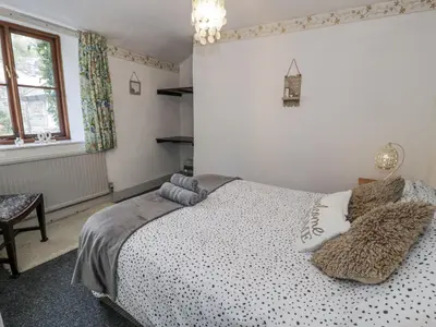 a bedroom with a bed with pillows on it at Old Post Office in Maentwrog