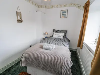 a small bedroom with a bed and a window at Old Post Office in Maentwrog