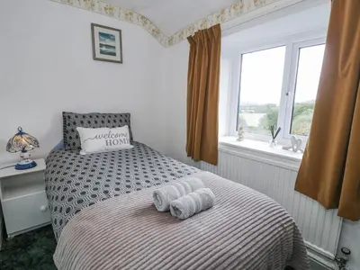 a bedroom with a bed with two towels on it at Old Post Office in Maentwrog